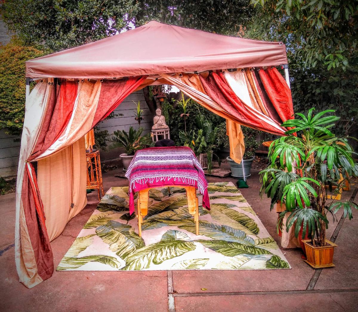 An outdoor massage table set up under a shade structure